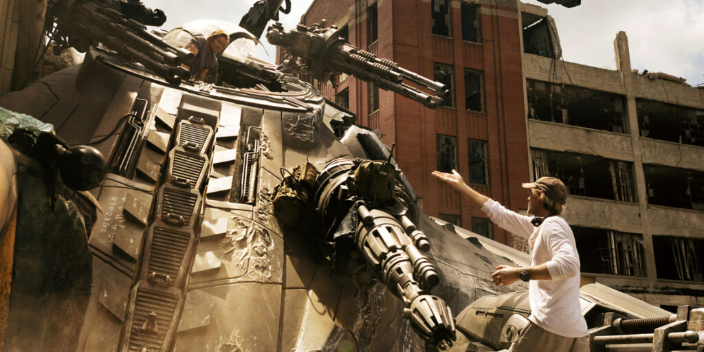 Photo Of Movie Set With Mark Wahlberg Inside A Giant Transformer , Michael Bay The Director Is Looking Up And Gesturing , Presumably Giving Some Direction To The Actor Inside The Giant Machine On The Movie Set Which Steph Calls The Transformers Debacle. 